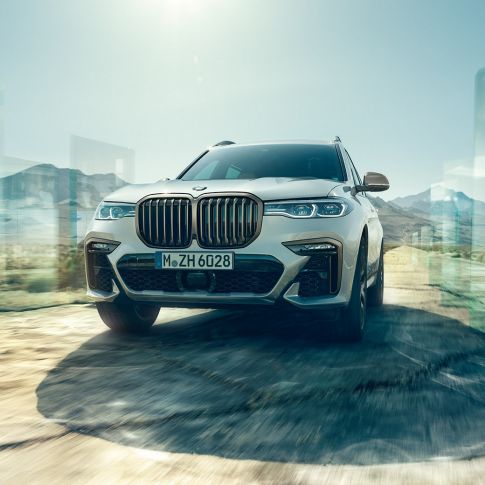 BMW X7 M50i, low-angle-shot BMW X7 M50i: oblique low-angle-shot of driving, white BMW X7