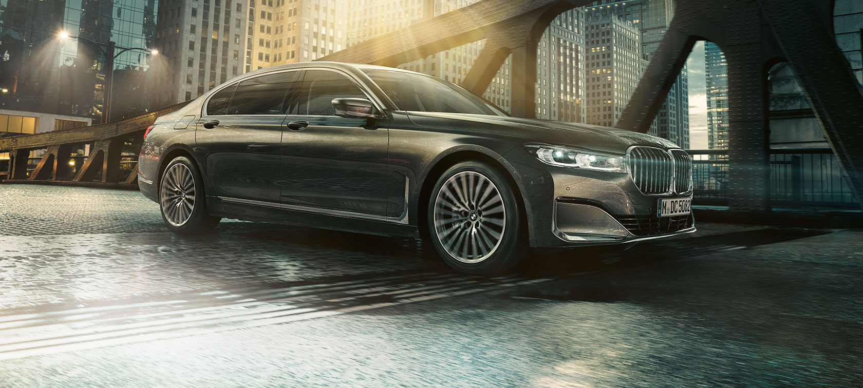 BMW 7 Series Sedan side view BMW 7 Series Sedan in side view with opened door in front of illuminated hotel
