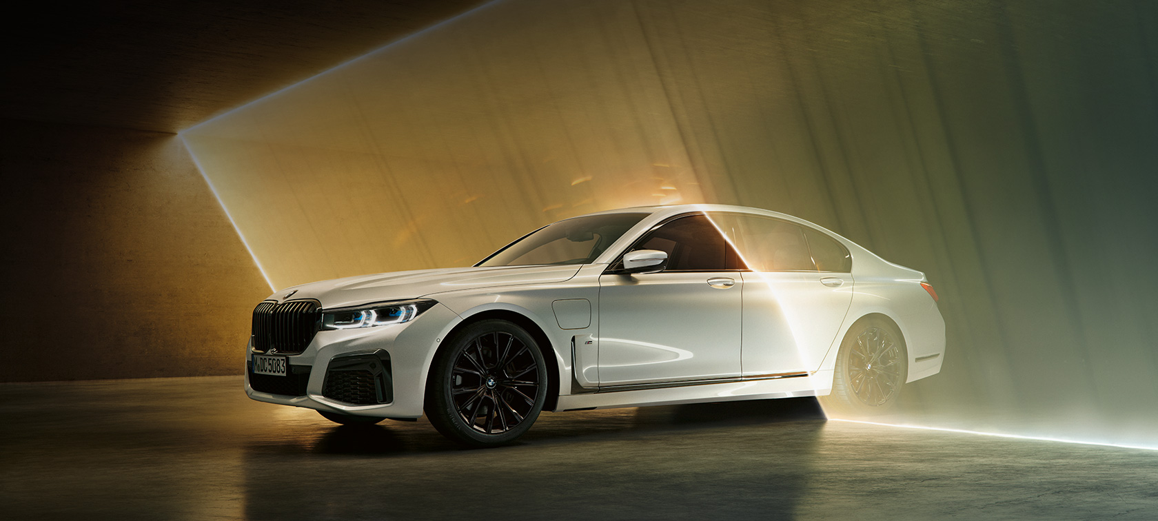 BMW 7 Series Sedan, white, three-quarter front view BMW 7 Series Sedan: white BMW in three-quarter front view surrounded by beam of light