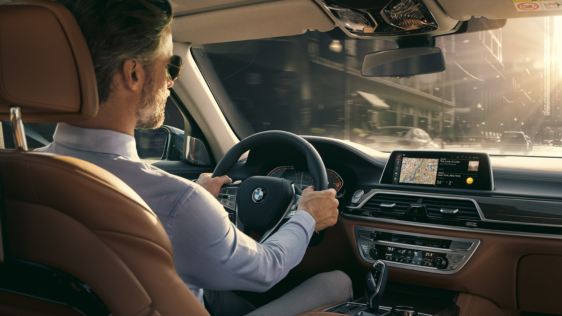 BMW 7 Series Sedan Connectivity features BMW 7 Series Sedan: man sits in BMW and uses Connectivity features