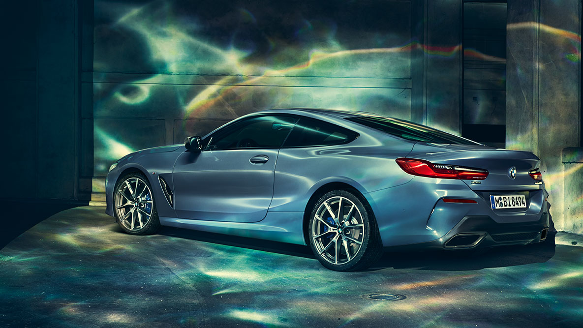 BMW 8 Series Coupé, three-quarter rear shot. Three-quarter rear shot of the BMW 8 Series Coupé at night in front of an urban setting.