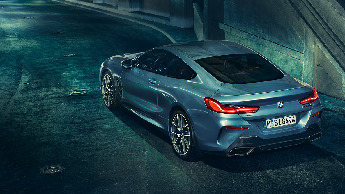 BMW 8 Series Coupé, three-quarter rear shot. Three-quarter rear shot of the BMW 8 Series Coupé at night in front of an urban setting.