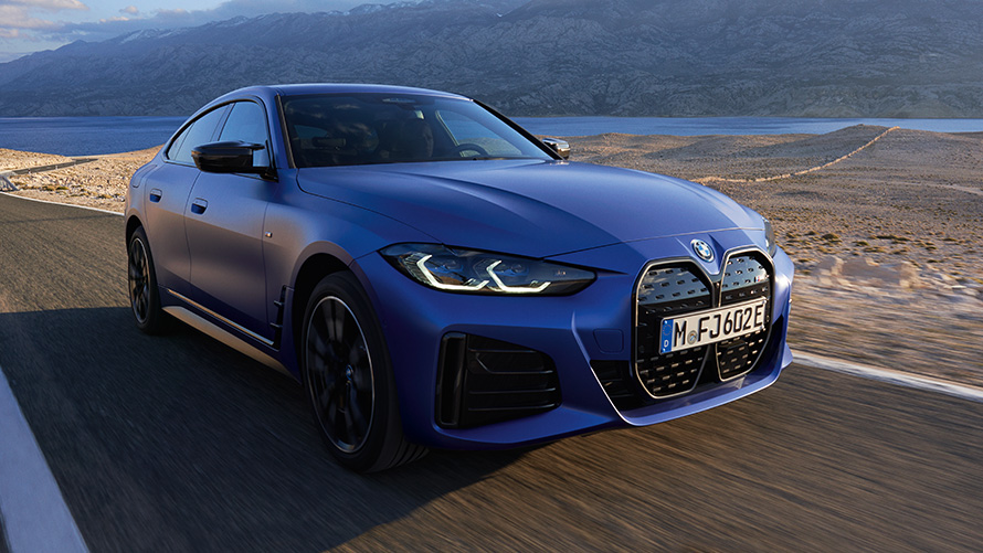 Three-quarter front view BMW i4 M50 G26 2021 BMW i4 M50 G26 2021 M Portimao Blue metallic three-quarter front view driving on the road