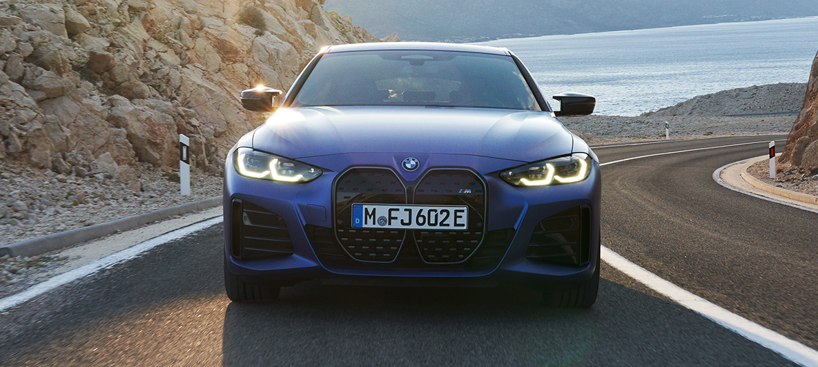 Front view BMW i4 M50 G26 2021 driving BMW i4 M50 G26 2021 M Portimao Blue metallic front view driving on the road