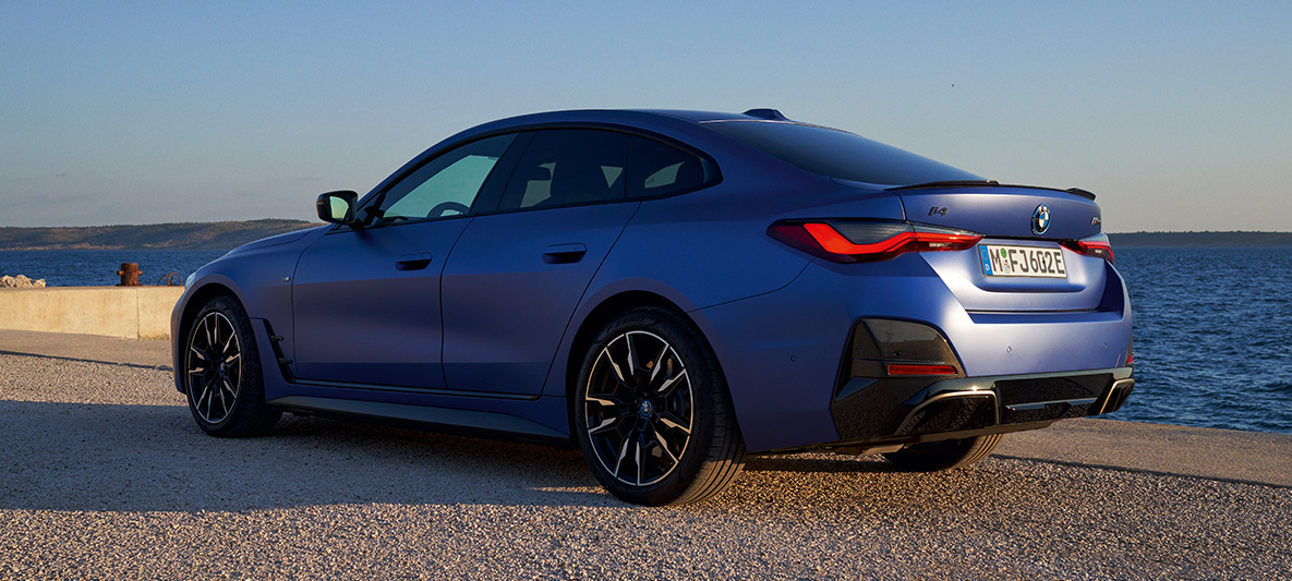 Three-quarter rear view BMW i4 M50 G26 2021 BMW i4 M50 G26 2021 M Portimao Blue metallic three-quarter rear view at the quay