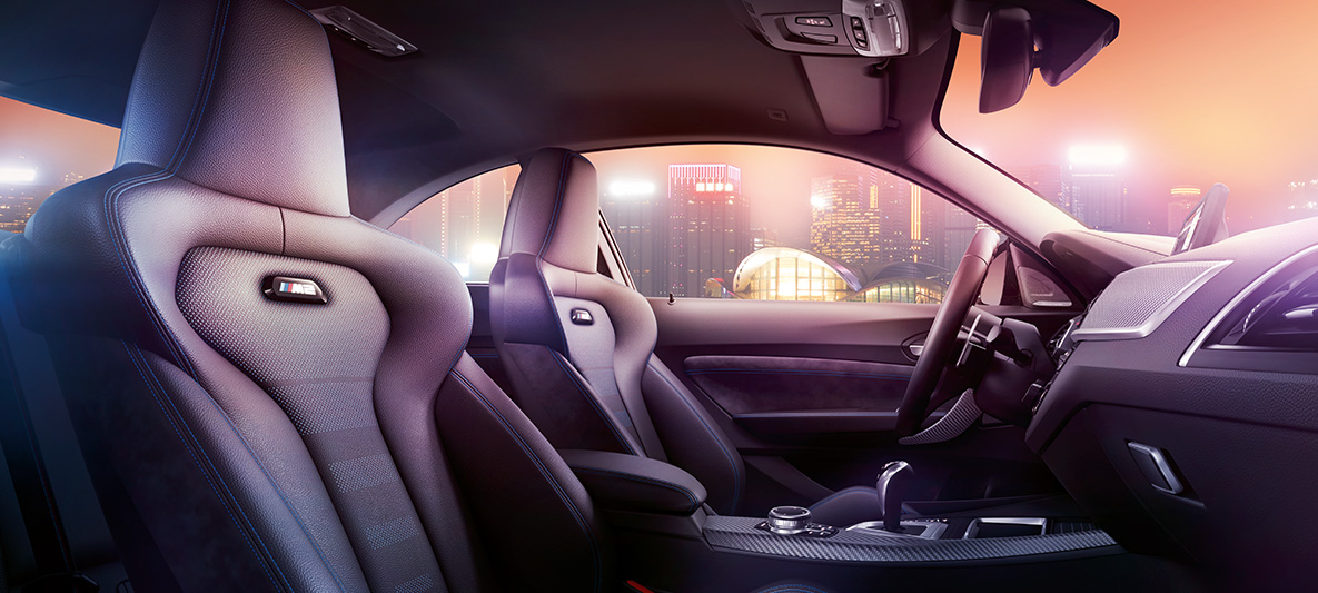 BMW M2 Competition Sport seats Cockpit and M Sport seats of the BMW M2 Competition, nocturnal skyline in the background.