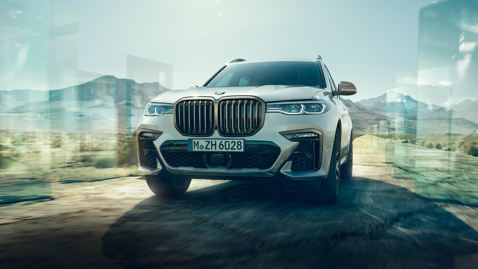 BMW X7 M50i, low-angle-shot BMW X7 M50i: oblique low-angle-shot of driving, white BMW X7