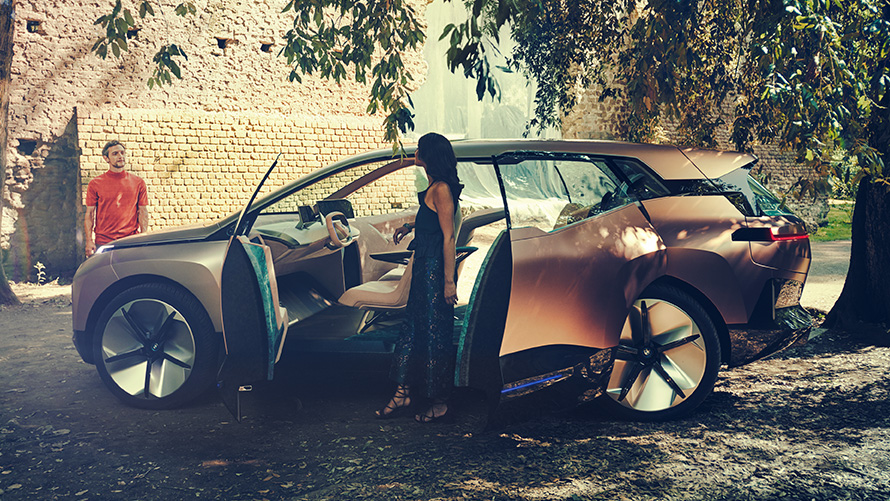 Side BMW Vision iNEXT Side BMW Vision iNEXT with woman at open doors and man in the background