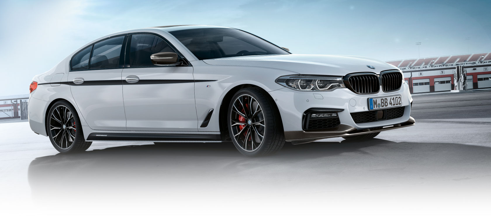 BMW 3 Series Sedan, M Performance Parts. Side view of the BMW 3 Series Sedan on a parking lot with blue sky.